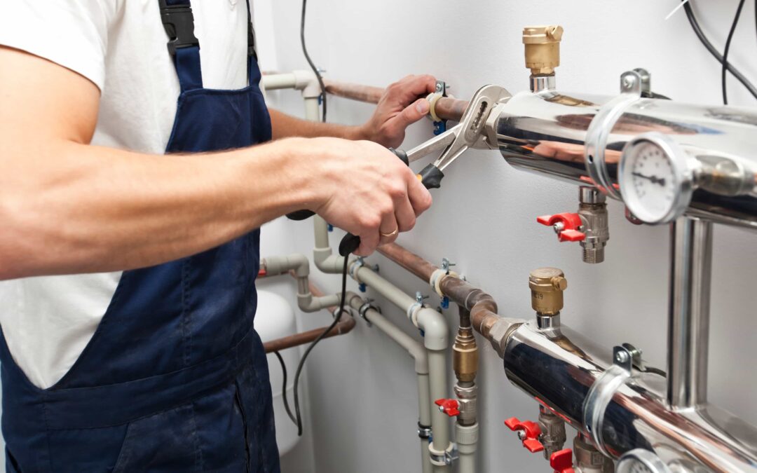 A plumber uses a wrench to tighten a pipe